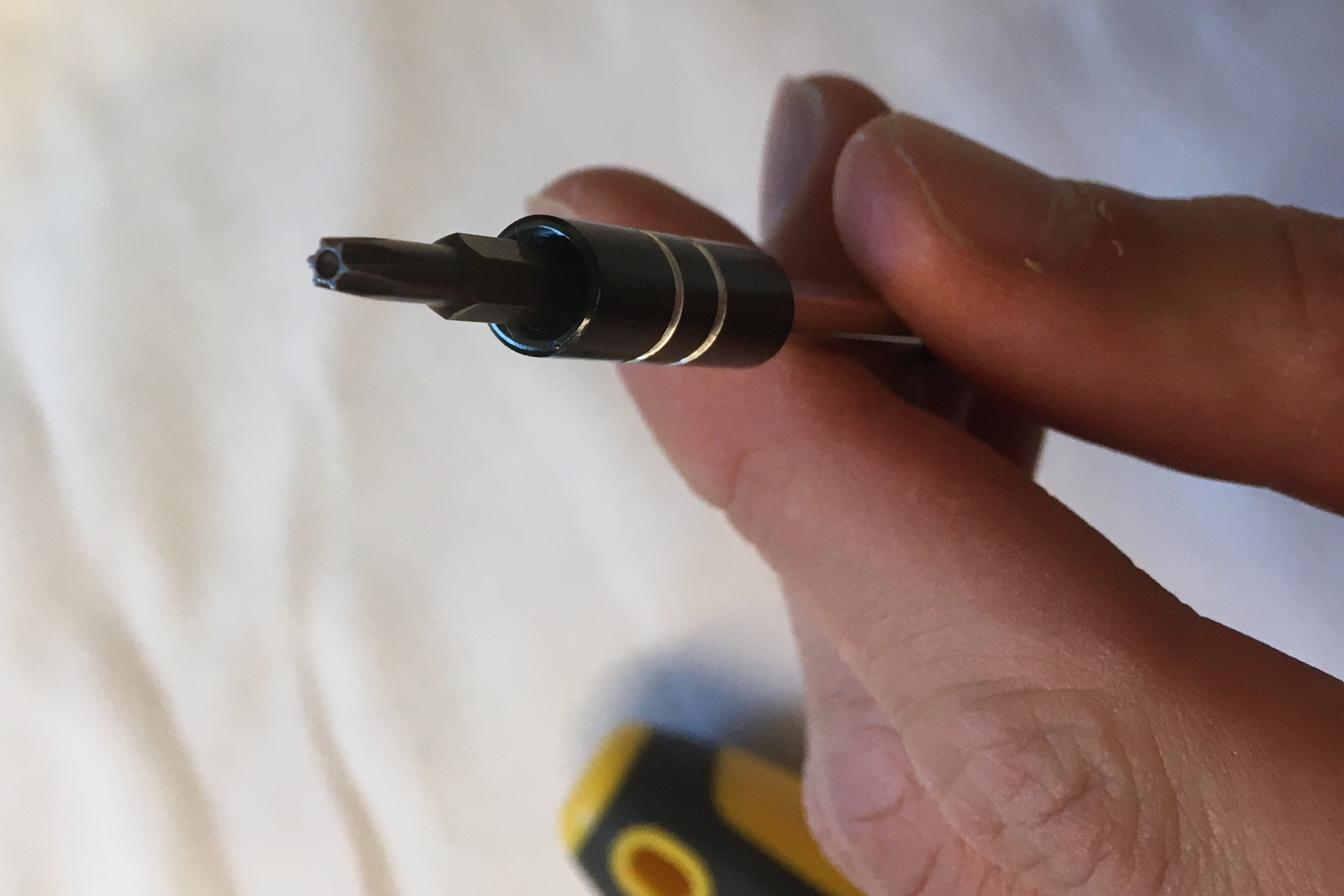 Small Brown Hexagon Star Screwdriver Held in Fingers